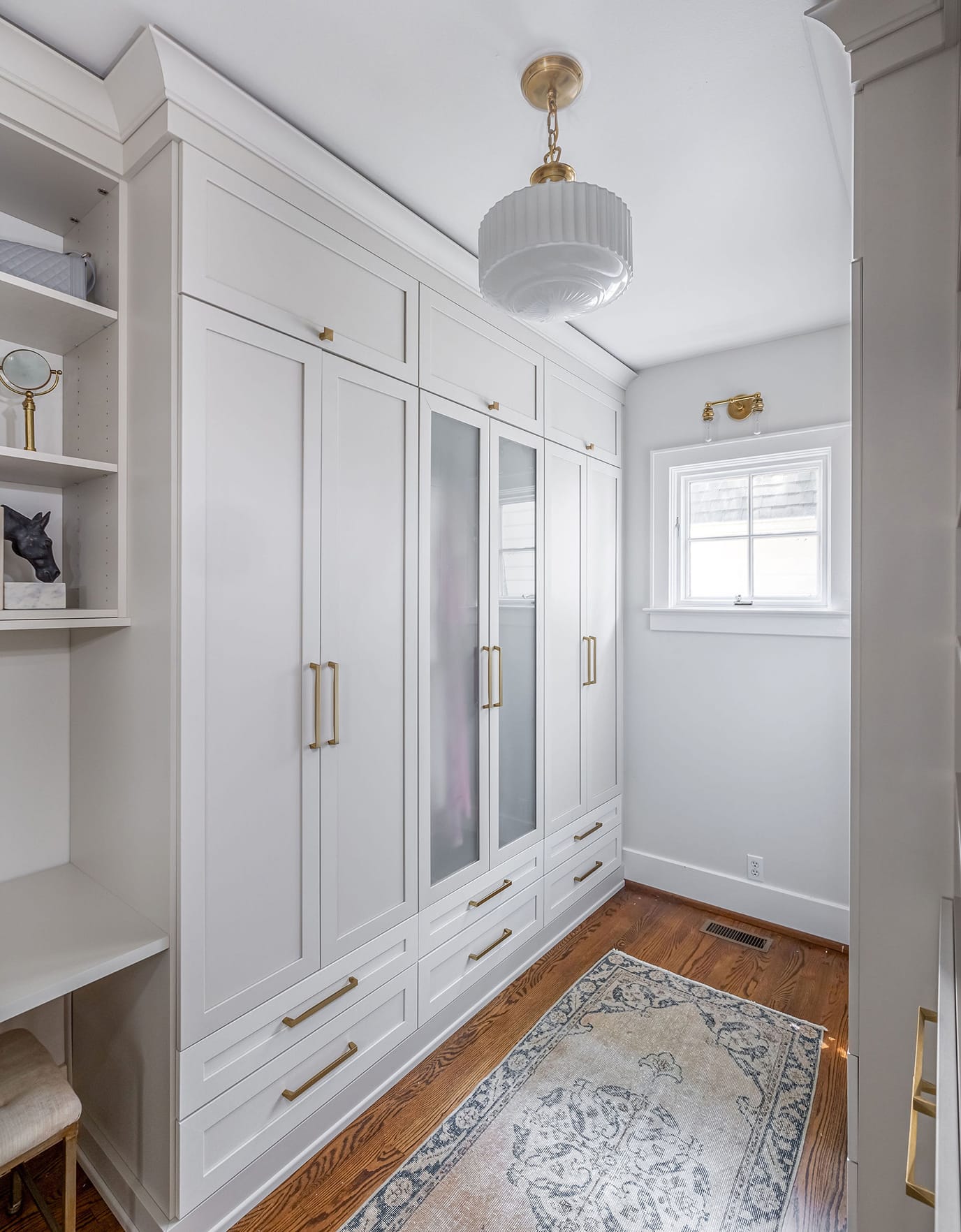 Pull out laundry cabinets in a walk in closet created for Candice King by California Closets