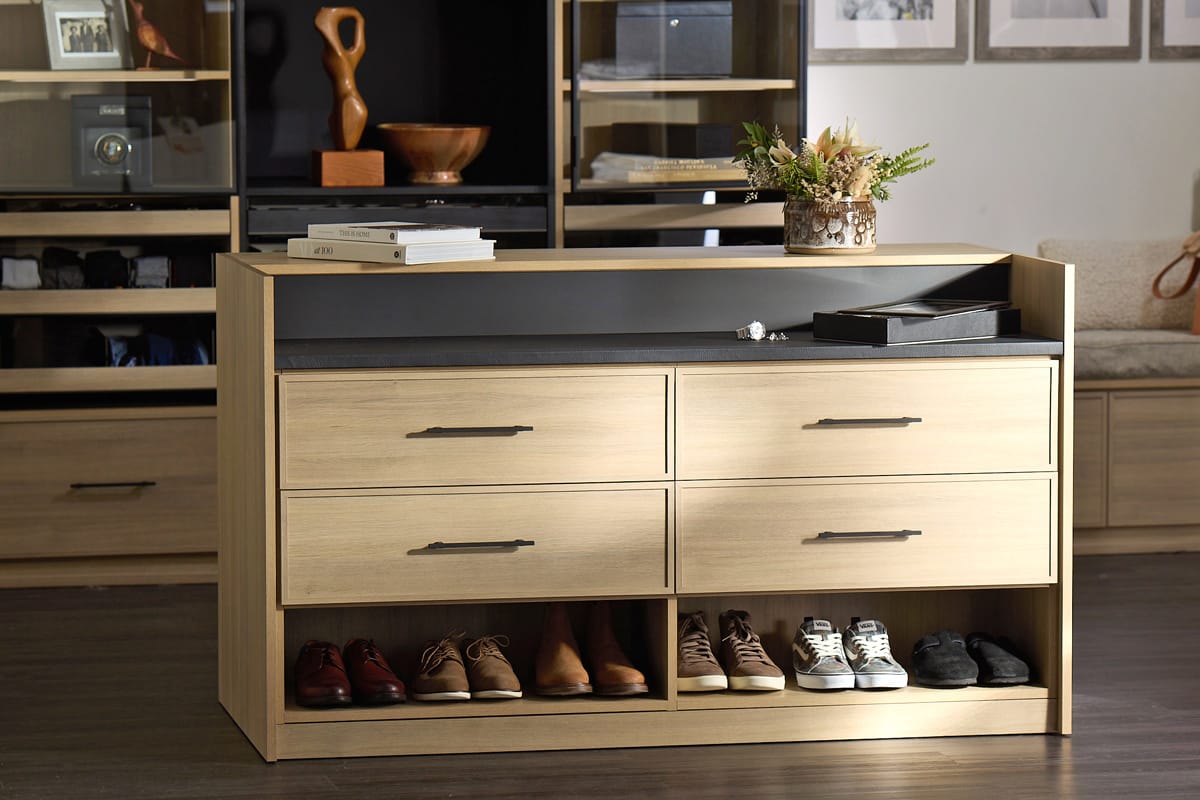 Storage center island in walk in closet for shoe storage and clothes accessories by California Closets