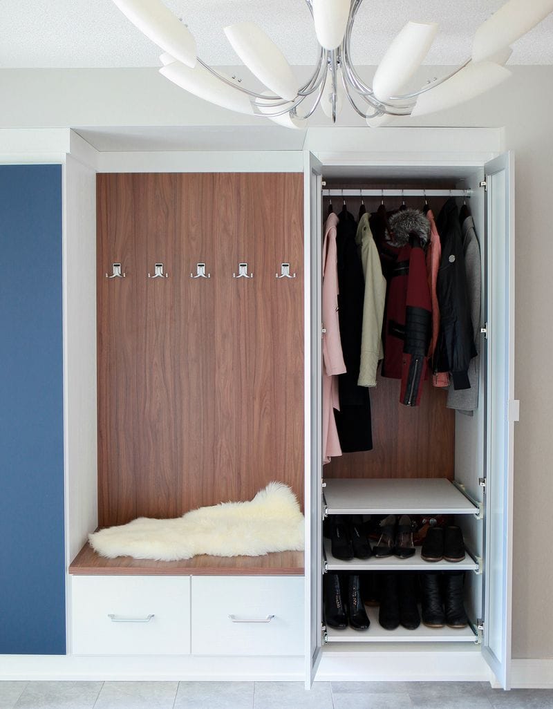 Opened cabinets in entryway mudroom showing shoe storage with bench by California Closets