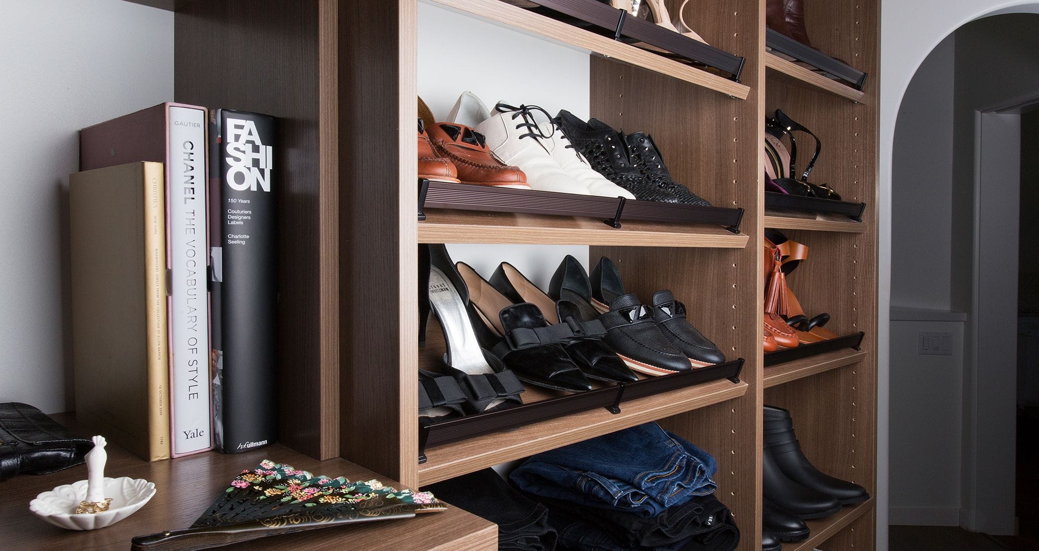 Custom walk-in closet built in shoe storage and dresser by California Closets