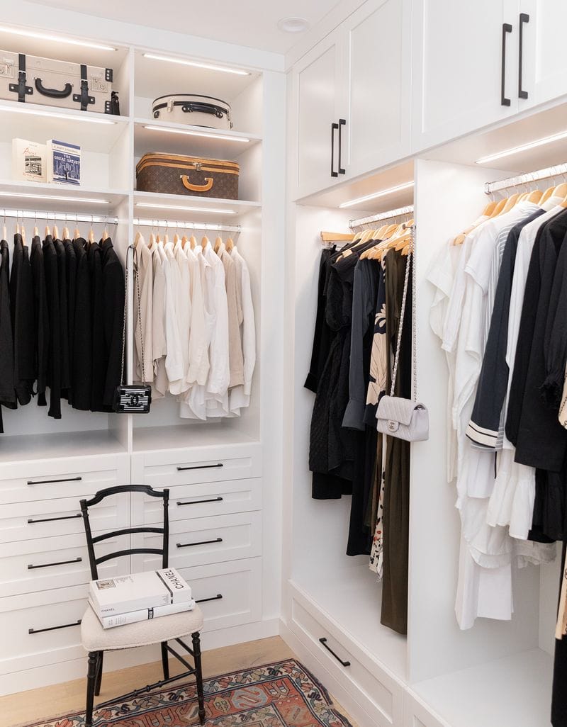 Closet detail with built in drawers, cabinets, overhead storage and open shelves in white finish by California Closets