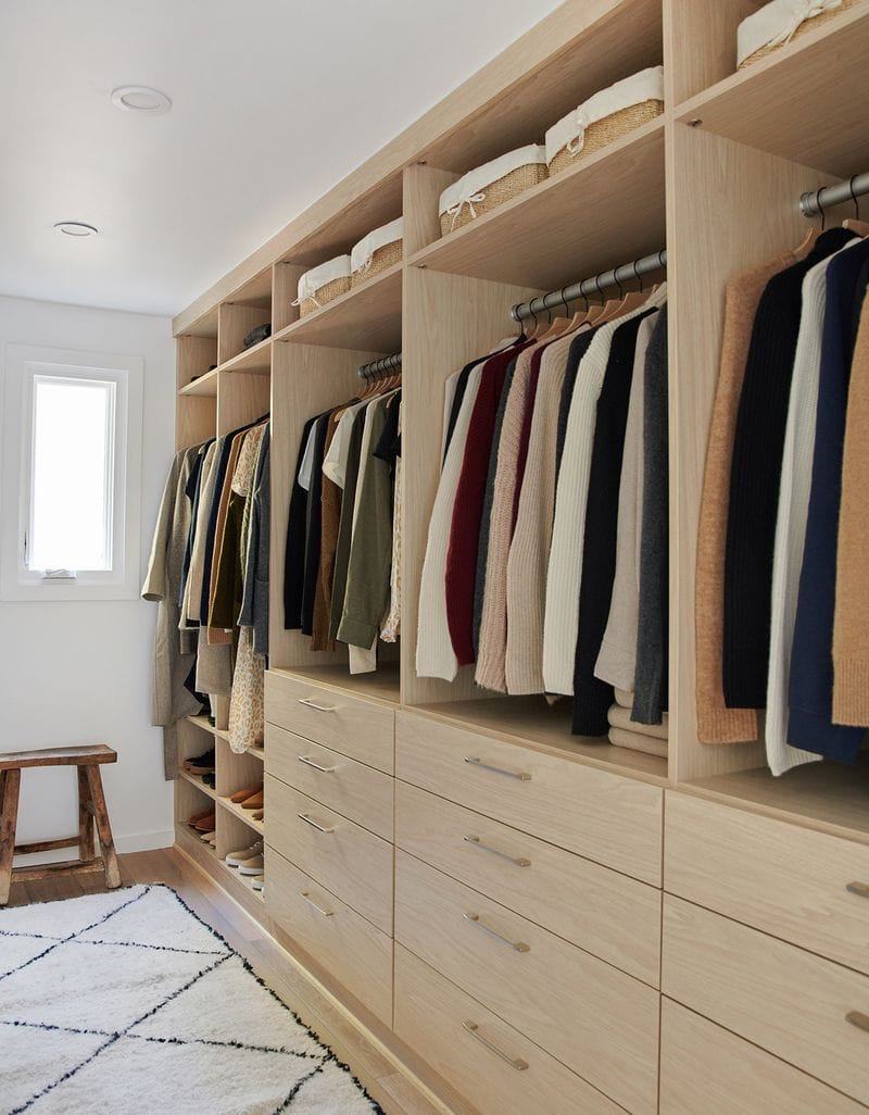 Walk in closet designed for Jenni Kayne with built in dresser drawers and shoe storage by California Closets