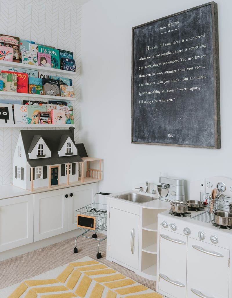 Playroom kitchen with a custom library for kids created with custom cabinets by California Closets