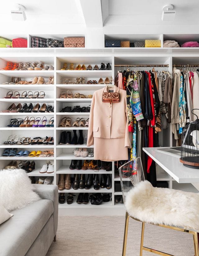 Customized shoe storage shelves created for Susan Magrin's custom closet with center table and seating by California Closets