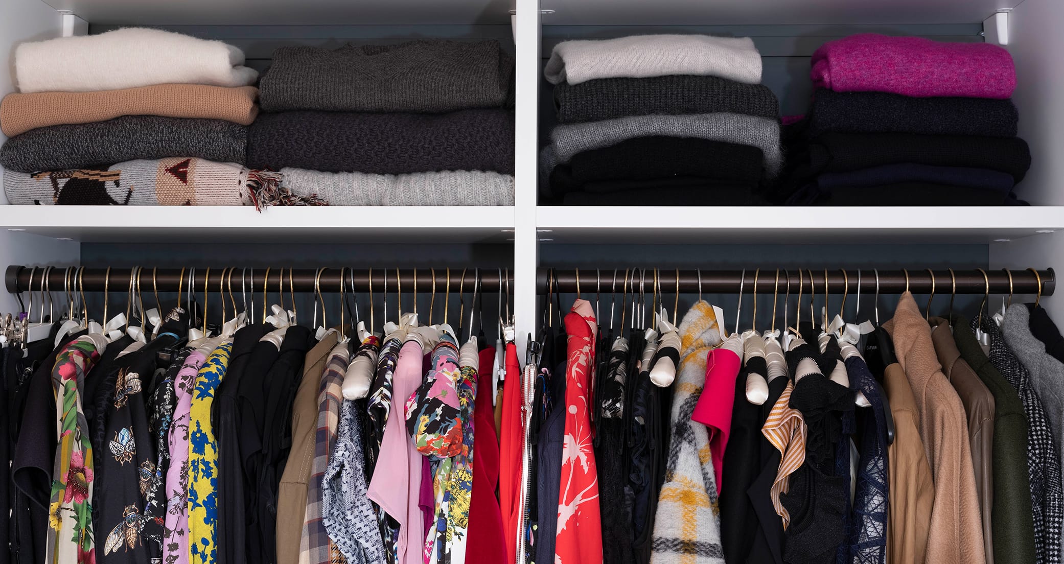 Custom wardrobe closet with open shelving for sweaters created by California Closets