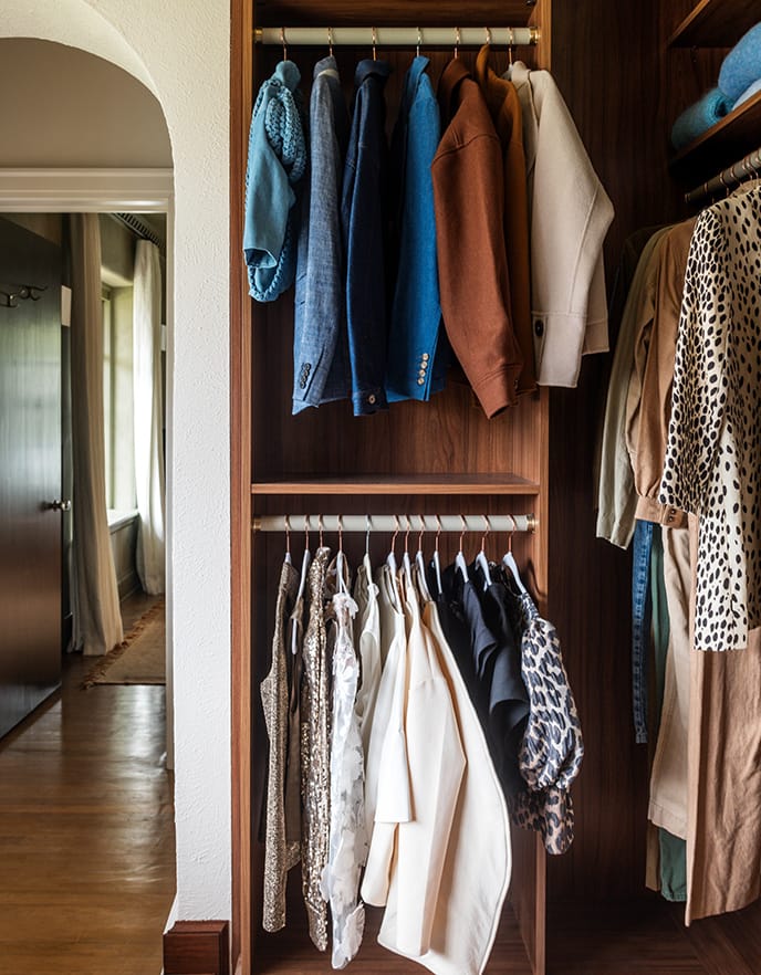 Double hanging wardrobe clothing rods in walk in closet designed for Sarah Sherman Samuel from California Closets.