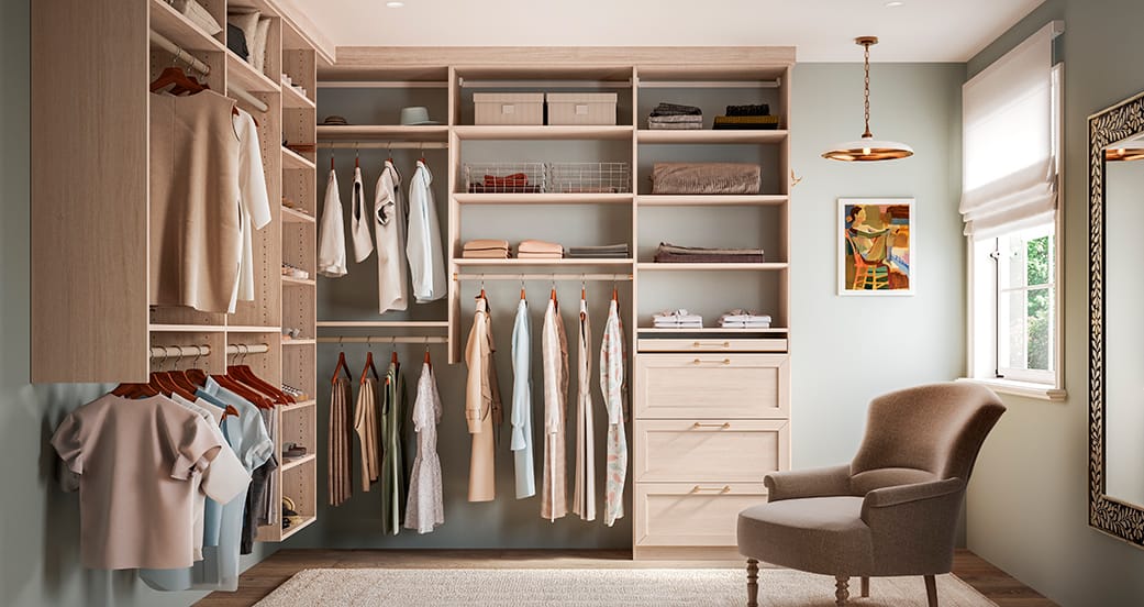Light wood walk in closet designed with shoe shelving and built in dresser drawers from California Closets