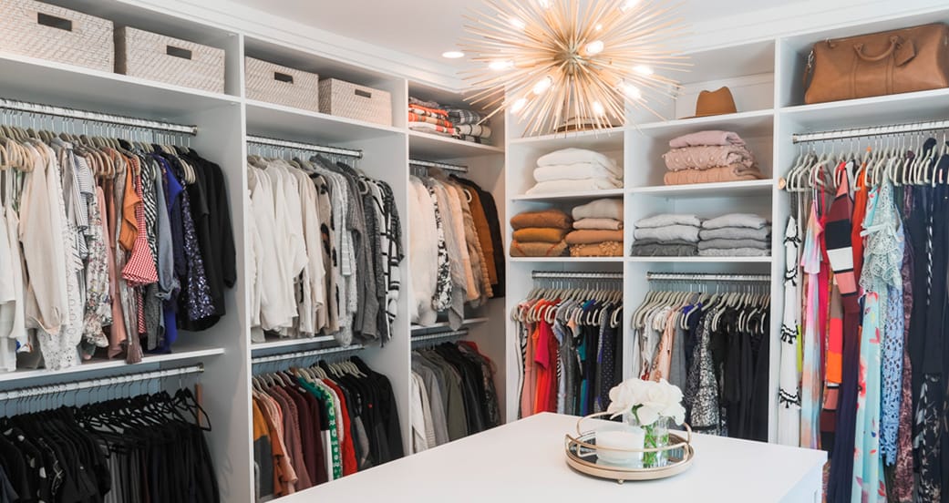 Walk in closet with central island storage in white wood finish from California Closets
