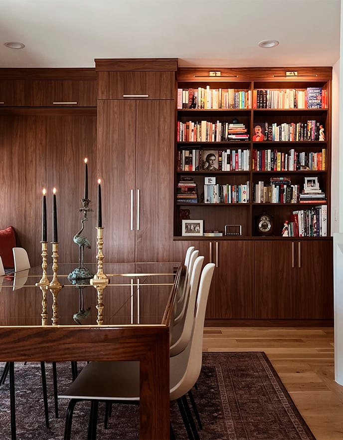 Front and side-view custom library shelving in dark wood finish and gold hardware from California Closets
