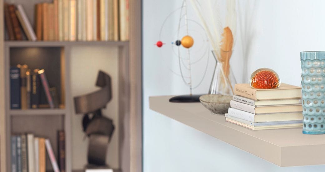 Open shelving next to custom counterspace for a personal library by California Closets