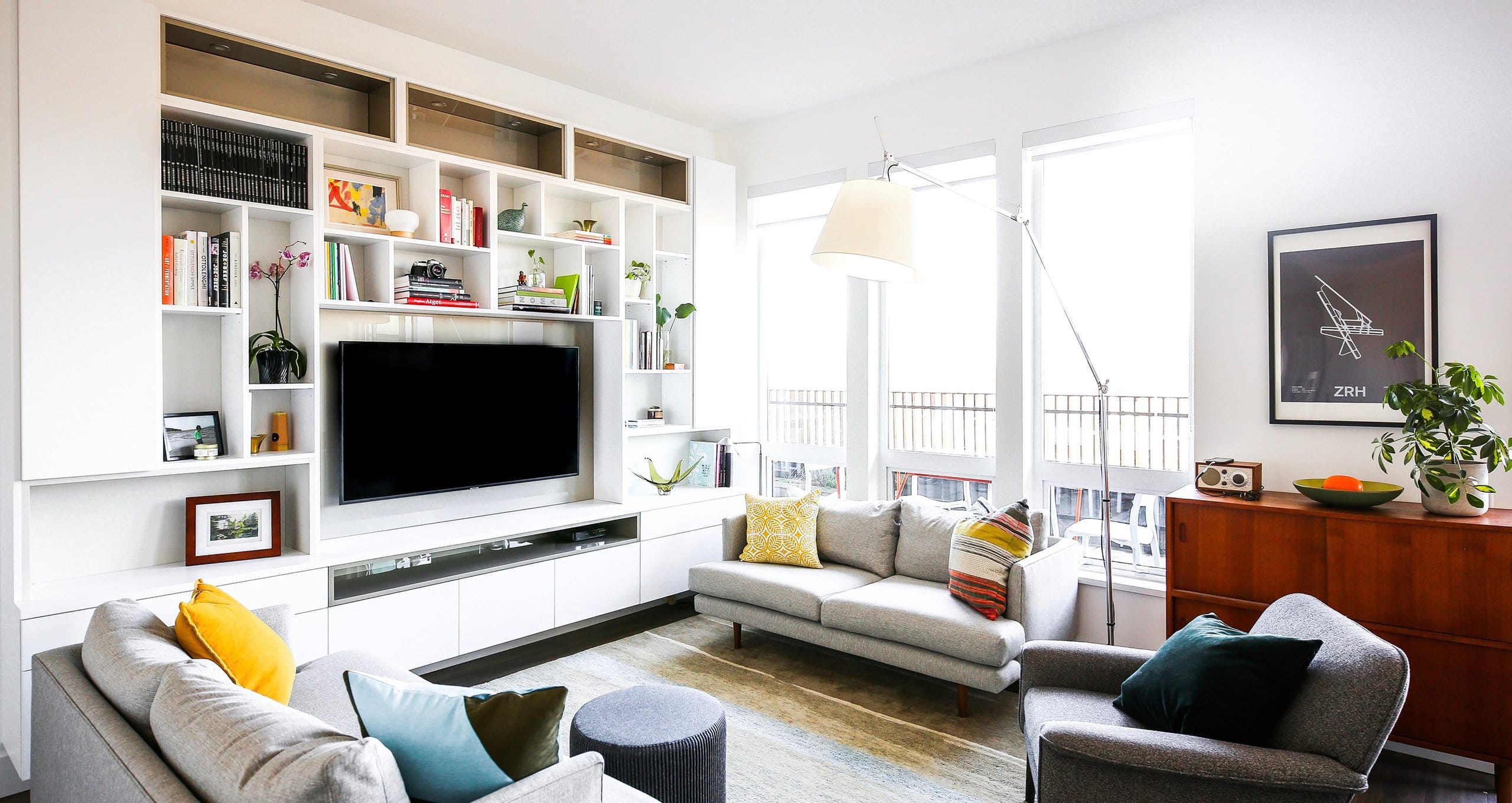 A custom media center in living room with surrounding built in shelves by California Closets