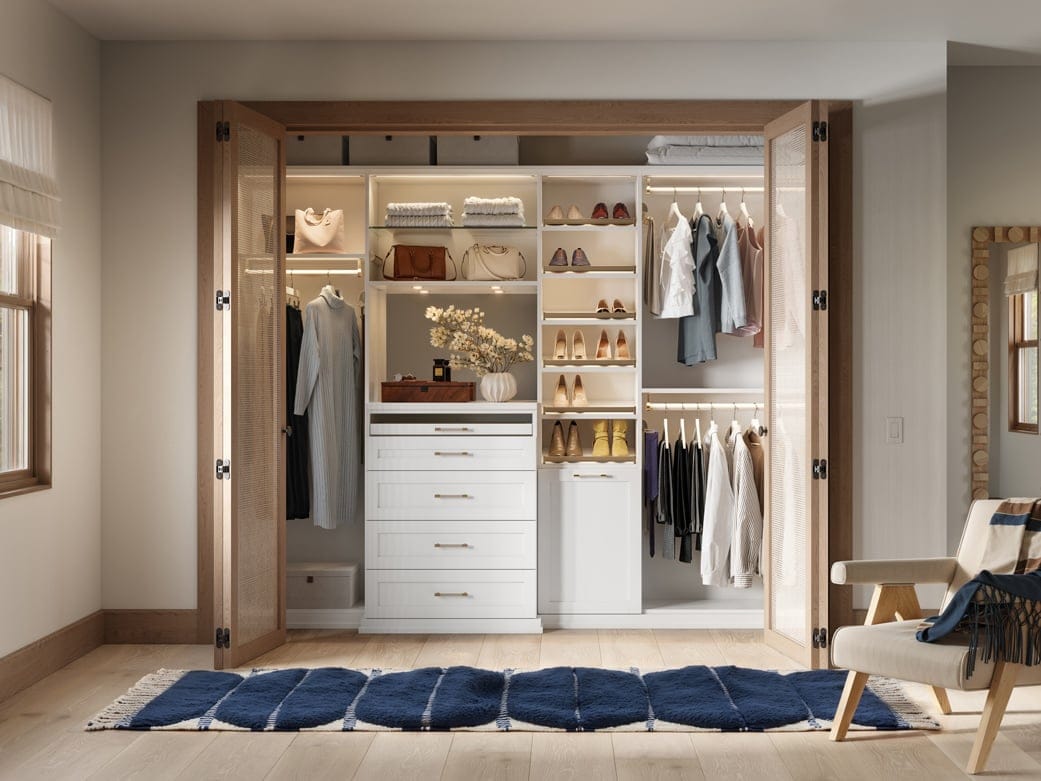Reach in closet with built in dresser, open shelves and custom lighting by California Closets